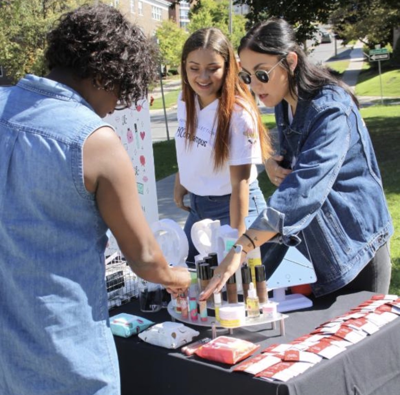 Students browsing a campus pop-up marketing table with products